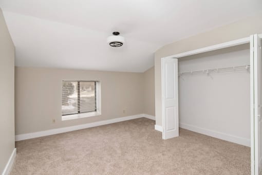 an empty bedroom with a closet and a window at Retro 511 Apartments, West Haven, CT