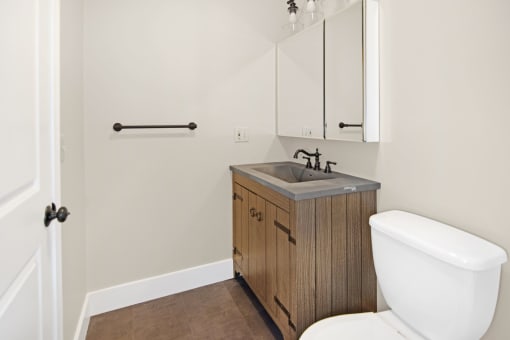 a bathroom with a toilet sink and a mirror at Retro 511 Apartments, West Haven