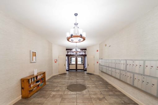 a long hallway with rows of lockers and a chandelier at Retro 511 Apartments, West Haven, CT 06516