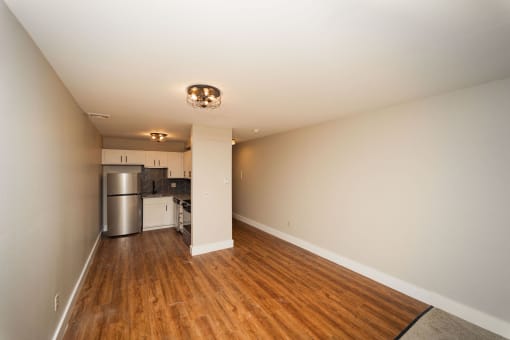 a renovated living room and kitchen with wood floors and white walls at Retro 511 Apartments, West Haven, 06516