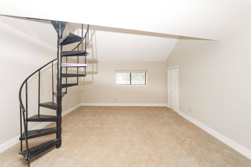 a small attic room with a spiral staircase and a window at Retro 511 Apartments, West Haven, Connecticut