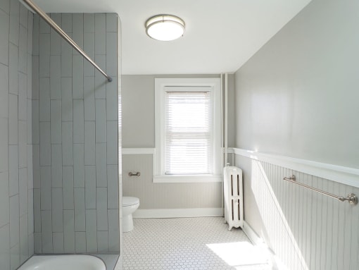 a white bathroom with a shower and a toilet at The Packard, Connecticut, 06119