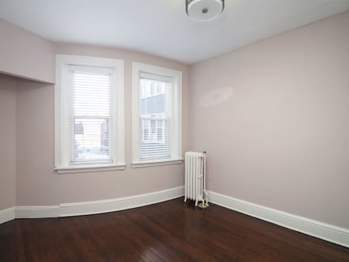 an empty room with a radiator and three windows at The Packard, Connecticut
