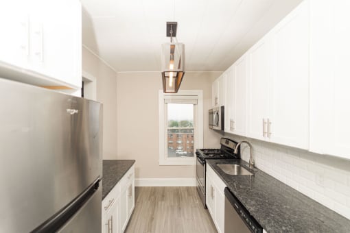 a kitchen with granite counter tops and stainless steel appliances at The Packard, West Hartford, Connecticut