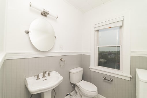 a white bathroom with a sink toilet and a window at The Packard, West Hartford, CT, 06119