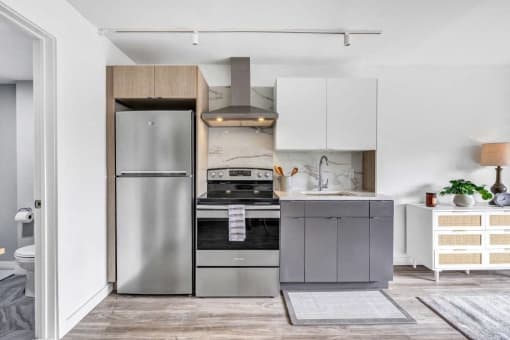 a small kitchen with stainless steel appliances and white cabinets at Up House, Farmington, 06032