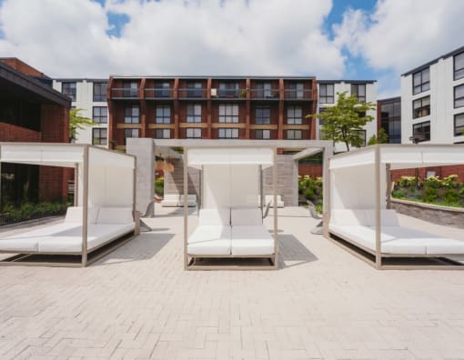 a seating area with white couches in front of a building at Up House, Farmington