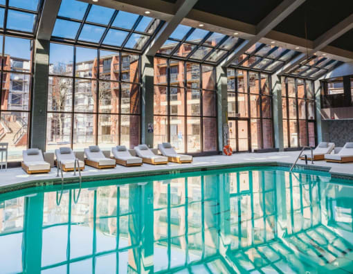 a swimming pool in front of a building with large windows at Up House, Connecticut, 06032