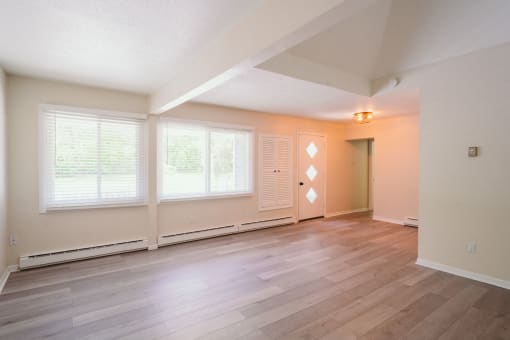 a spacious living room of an empty home with wood flooring and large windows at Woodbury, Woodbury, 06798