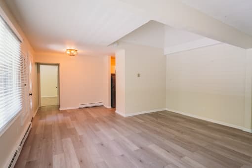 an empty living room with wood floors and a window at Woodbury, Connecticut