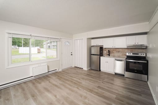 an empty kitchen with a large window and a stove and refrigerator at Woodbury, Connecticut