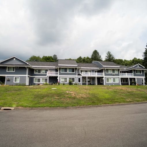 a large apartment building on a grassy hillat Woodbury, Woodbury, CT, 06798
