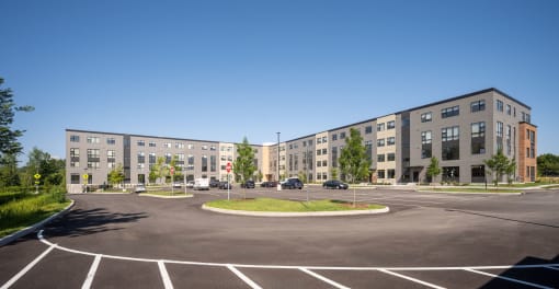 an empty parking lot in front of a large apartment building