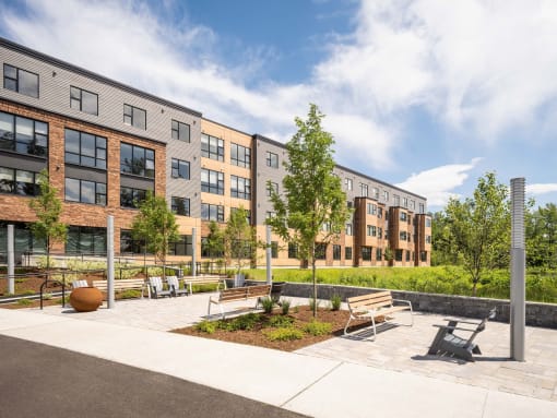a courtyard with benches and trees in front of a building
