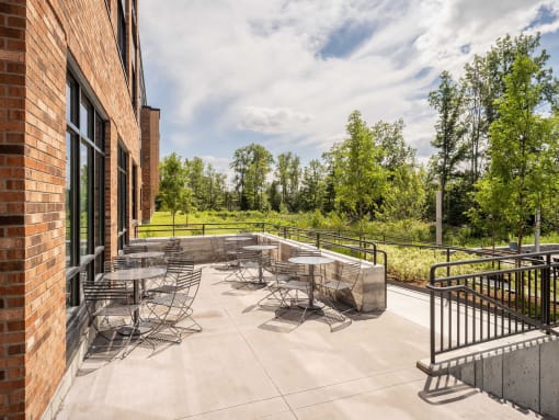 a patio with tables and chairs outside of a brick building