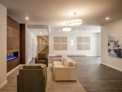 a long hallway with couches and chairs and a fireplace