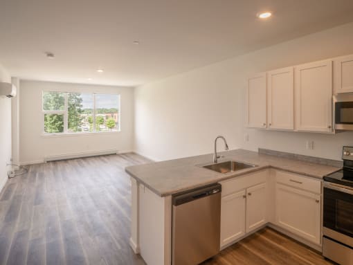an empty kitchen with white cabinets and a sink