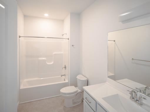 A white bathroom with a toilet, sink, and bathtub.