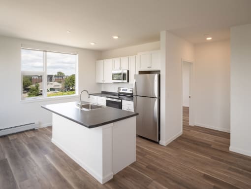 a kitchen with a island and a stainless steel refrigerator
