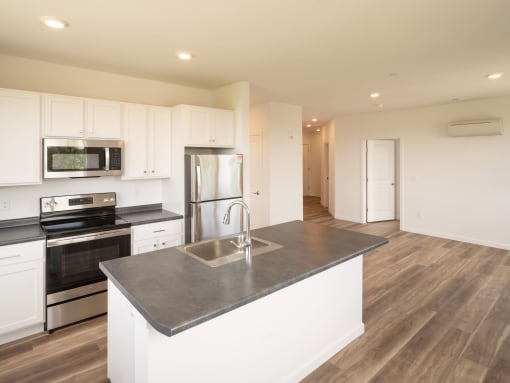 a kitchen with white cabinets and stainless steel appliances