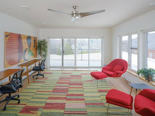 A room with a red carpet and a ceiling fan.