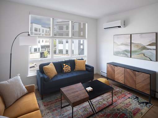 A living room with a blue couch and a wooden coffee table.