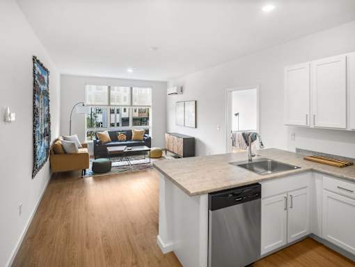 A modern kitchen with a dining area and a living room.