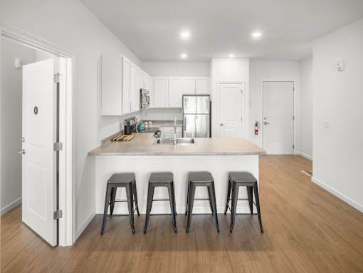 A kitchen with white cabinets and a white door.