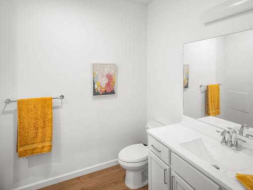 A bathroom with a toilet, sink, and towel.