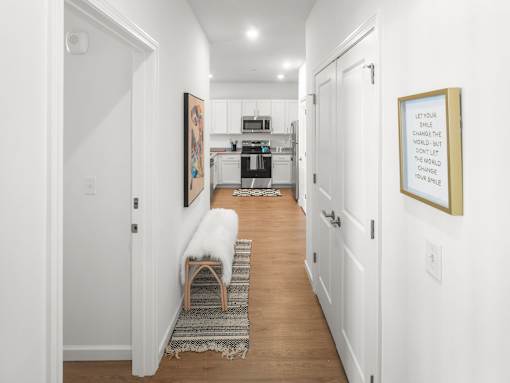 A hallway with a bench and a framed quote on the wall.