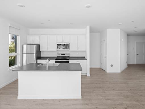 A modern kitchen with white cabinets and a large island.