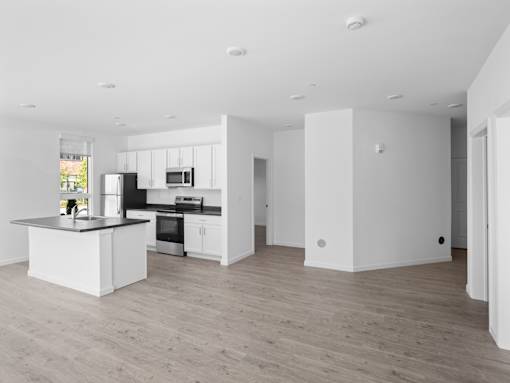A modern kitchen with a large island and wooden floors.