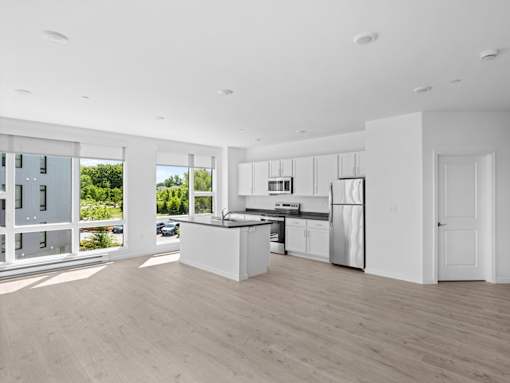 A modern kitchen with white appliances and cabinets.