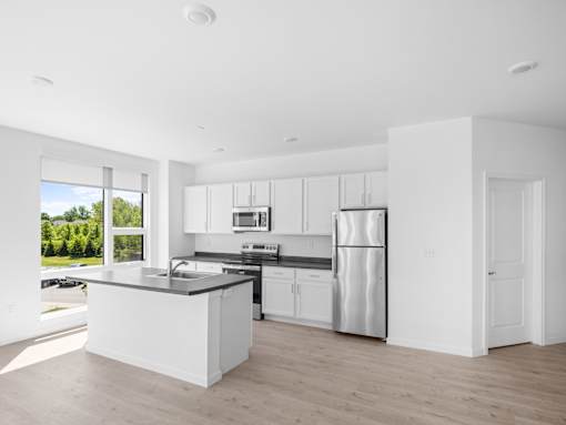 A modern kitchen with white cabinets and a large island.