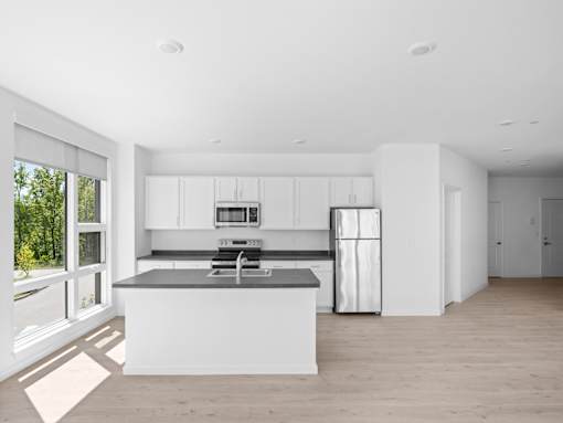 A modern kitchen with a large island and stainless steel appliances.