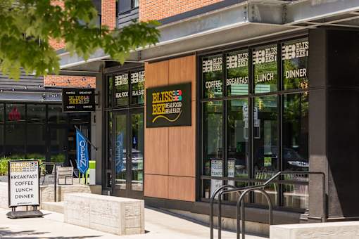 A restaurant named Bliss Brew House has a sign outside advertising breakfast, lunch, and dinner.