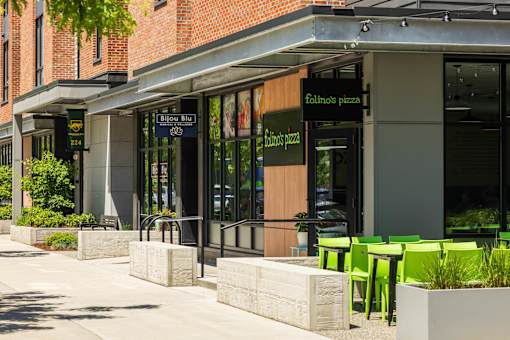 A restaurant with green chairs outside.