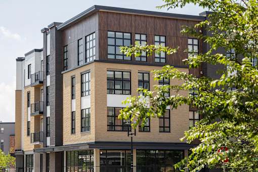 A modern multi-story building with balconies and large windows.