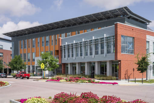 a large brick building with a metal roof and a parking lot in front of it