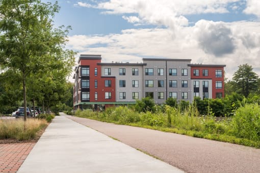 a large apartment building with a sidewalk in front of it