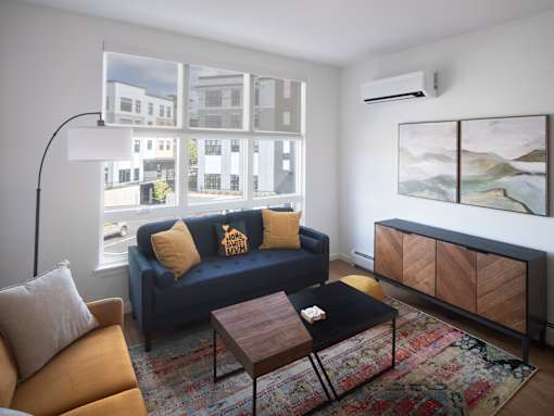 A living room with a blue couch and a wooden coffee table.