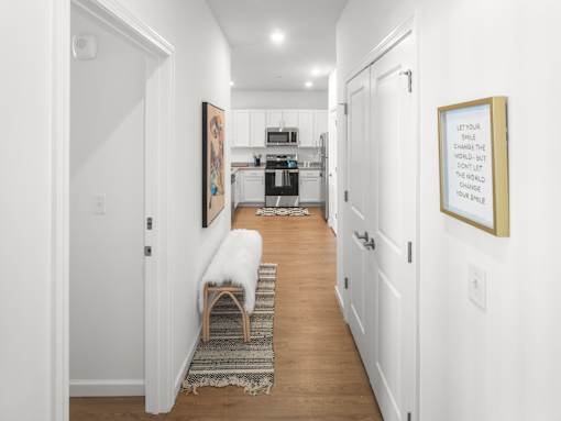 A hallway with a bench and a picture on the wall.