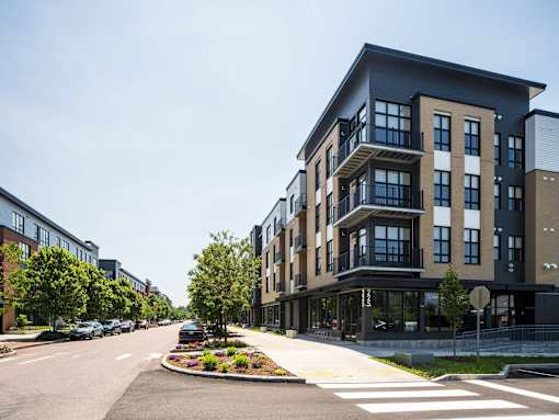 A modern apartment building with a landscaped median in front of it.