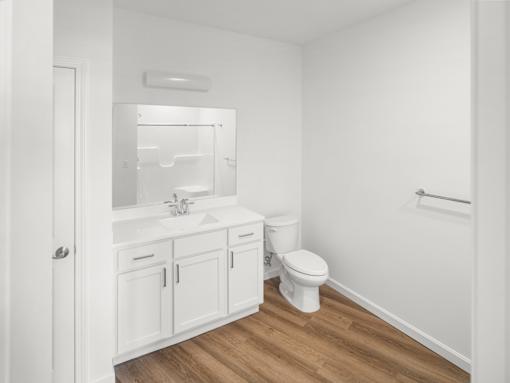 A white bathroom with a toilet, sink, and medicine cabinet.