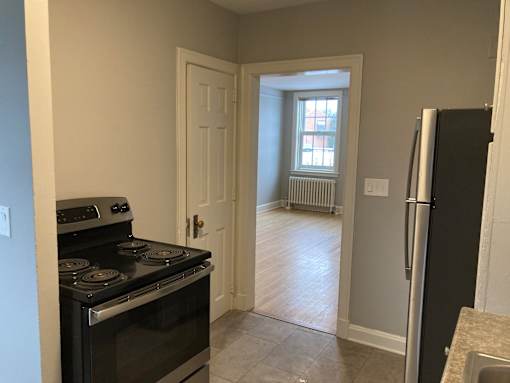 A kitchen with a black stove top oven and a black refrigerator.