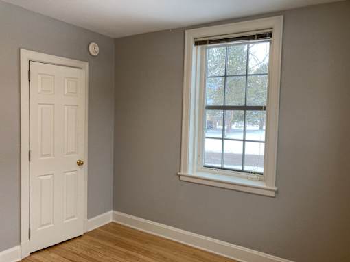 A room with a white door and a window.