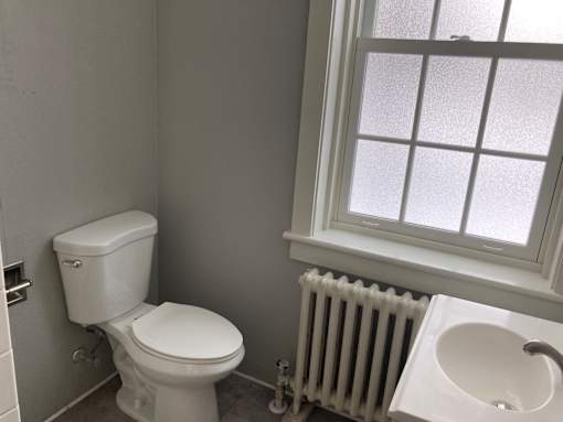 A white toilet sits next to a white sink in a bathroom.