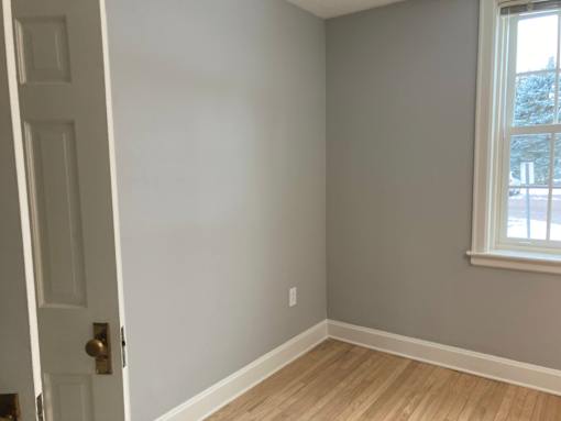 A room with a white door and a window.