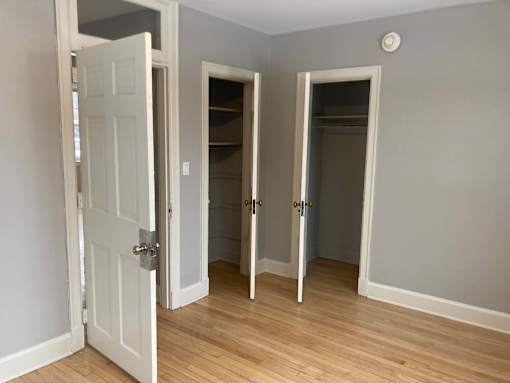 A room with a white door and two other doors with no windows.
