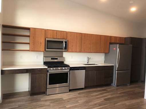 A modern kitchen with a stainless steel refrigerator, oven, and microwave.